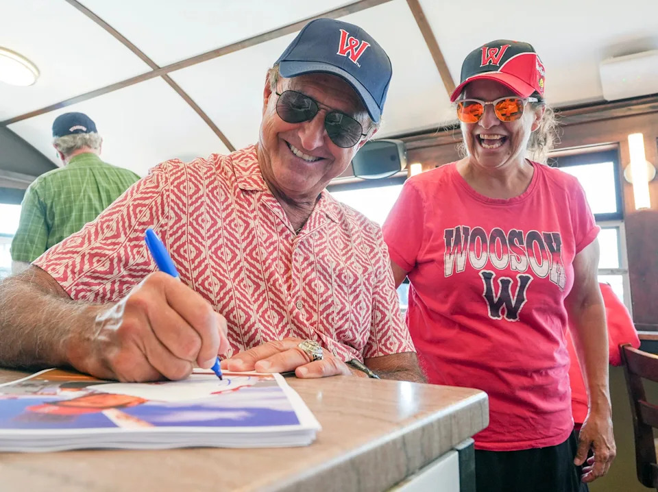 Former Red Sox outfielder Fred Lynn signs a photo for Charlene Gryszowka of Ware inside Sherwood’s Diner at Polar Park August 7.