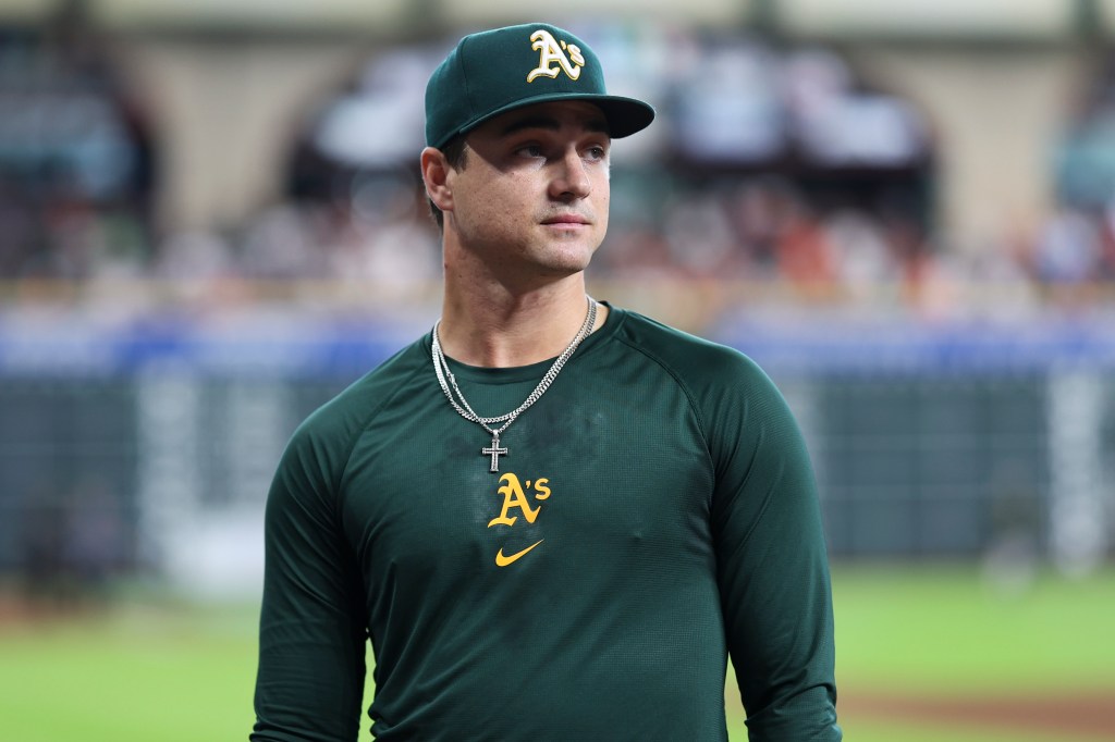 Oakland A's baseball player wearing a green long-sleeve shirt.