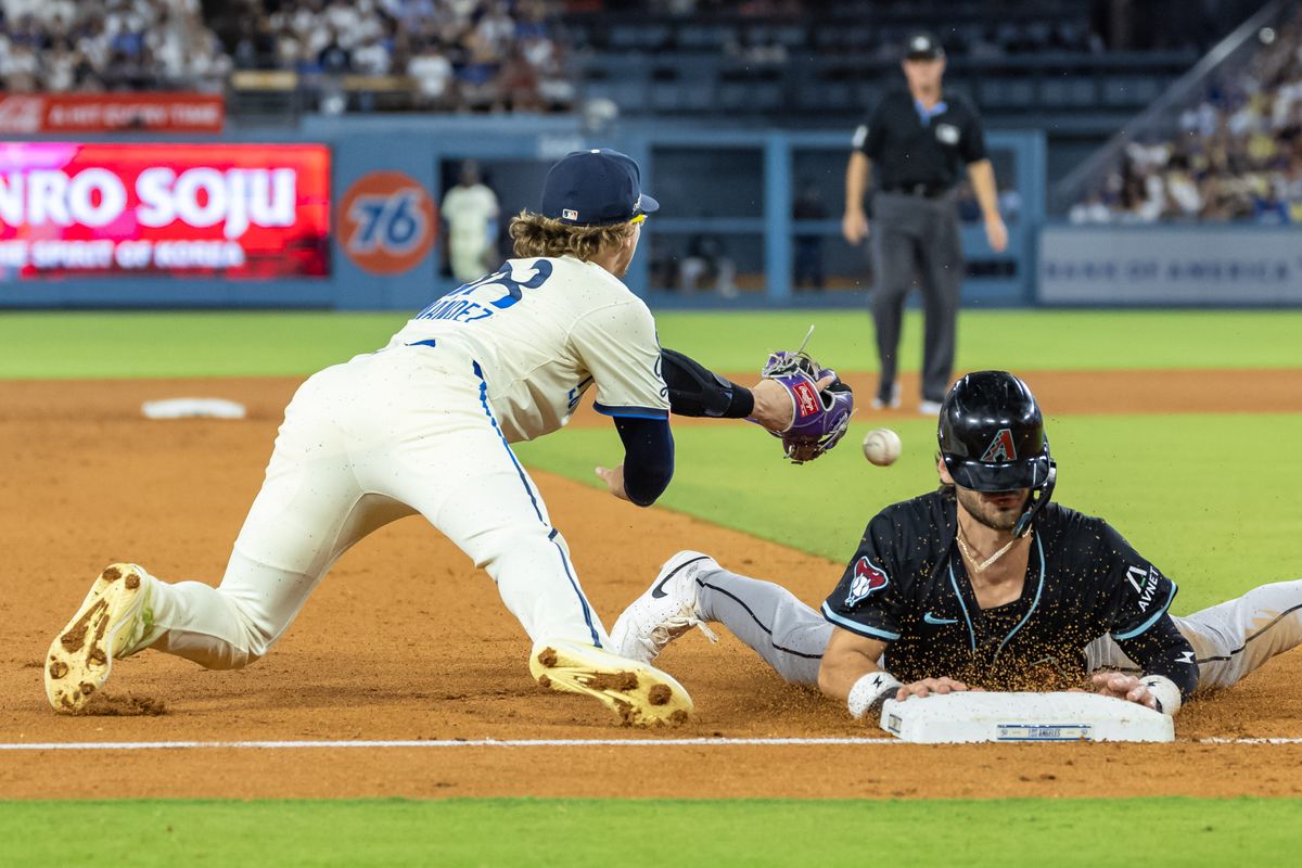 The ball sneaks past the glove of Enrique Hernández #8 of the Los Angeles Dodgers as he tries to tag Blaze Alexander #9 of the Arizona Diamondbacks during an MLB game at Dodger Stadium on August 30, 2025 in Los Angeles, California. The ball sneaks past the glove of Enrique Hernández #8 of the Los Angeles Dodgers as he tries to tag Blaze Alexander #9 of the Arizona Diamondbacks during an MLB game at Dodger Stadium on August 30, 2025 in Los Angeles, California.