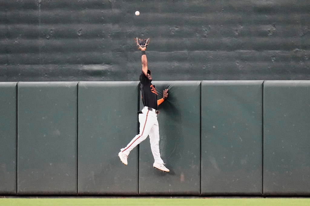 Baltimore Orioles center fielder Cedric Mullins jumps to catch a fly ball hit by Toronto Blue Jays' Nathan Lukes.