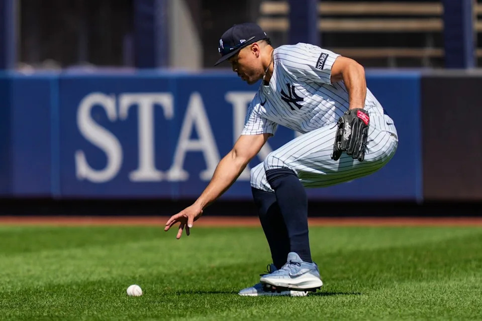 Giancarlo Stanton picks up a ball in the outfield during the Yankees’ game against the Astros on Aug. 9. AP