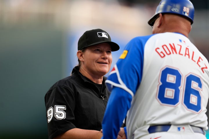 Umpire Jen Pawol speaks with Atlanta Braves third baseman coach Fredi González (86) in the first inning in the second baseball game of a doubleheader between the Atlanta Braves and the Miami Marlins, Saturday, Aug. 9, 2025, in Atlanta. (AP Photo/Mike Stewart)