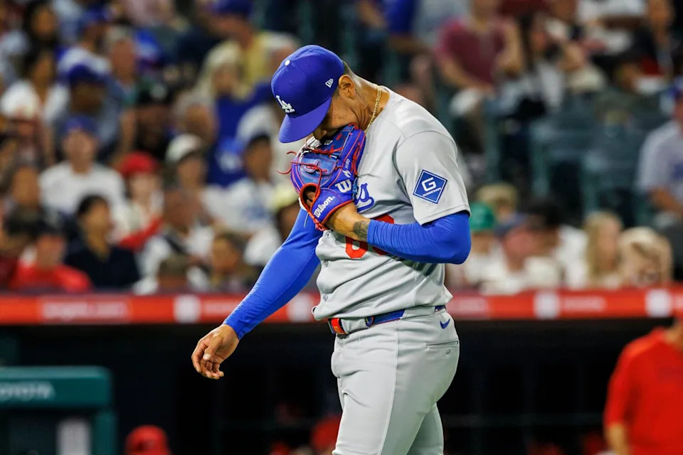 Dodgers pitcher Edgardo Henriquez bites his glove as he walks off the mound after giving up the go-ahead run.