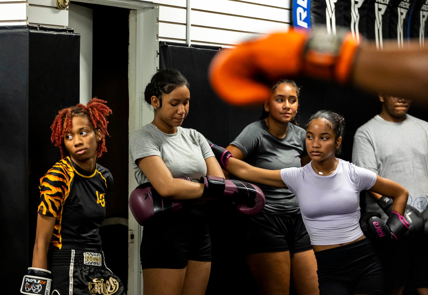 Students stood against the wall during practice at Level Ground Mixed Martial Arts on July 7.