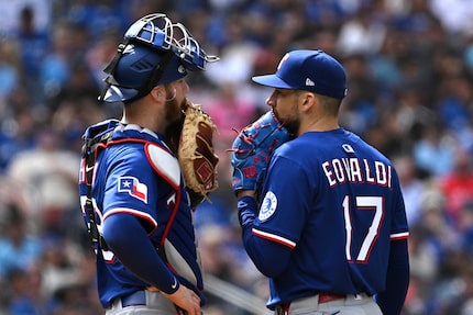 Texas Rangers catcher Jonah Heim, left, visits Texas Rangers starting pitcher Nathan Eovaldi...
