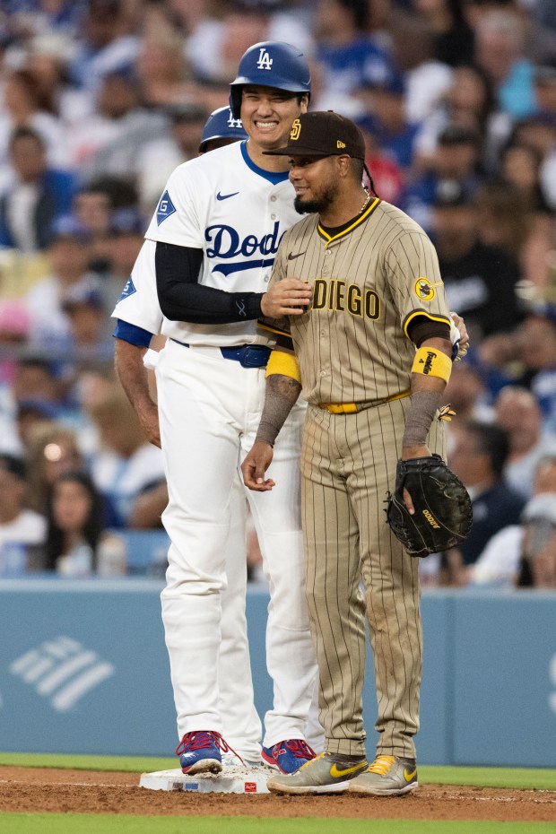 The Dodgers' Shohei Ohtani laughs with Padres first baseman Luis Arraez after Ohtani was hit by a pitch on June 17, 2025. (AP Photo/Kyusung Gong)