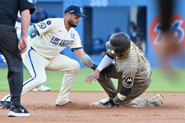 Dodgers second baseman Miguel Rojas, second from right, tags out...