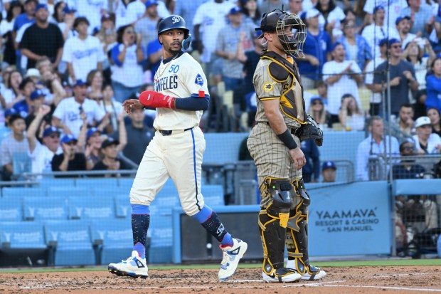 The Dodgers’ Mookie Betts scores a run in front of...