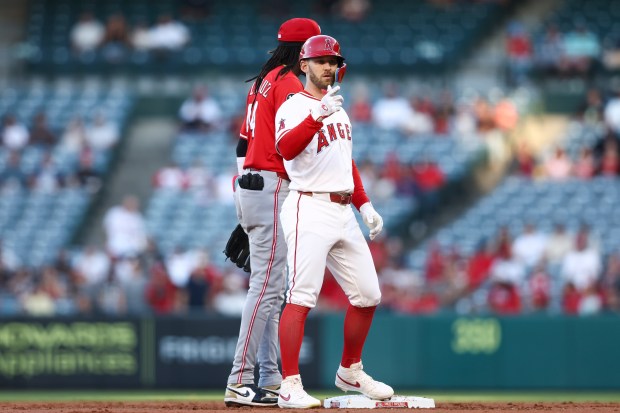 The Angels’ Taylor Ward, right, gestures after hitting an RBI...
