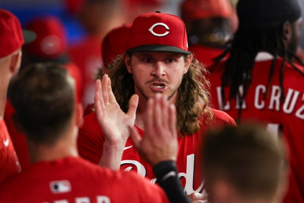 Cincinnati Reds pitcher Scott Barlow celebrates in the dugout with...
