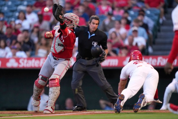 Angels star Mike Trout, right, scores on a single by...