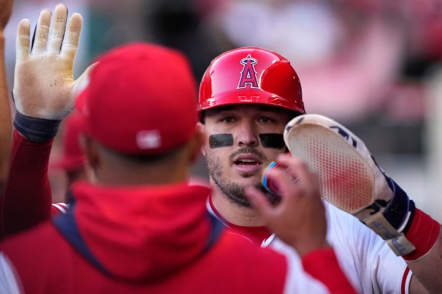 Angels star Mike Trout is congratulated by teammates in the...