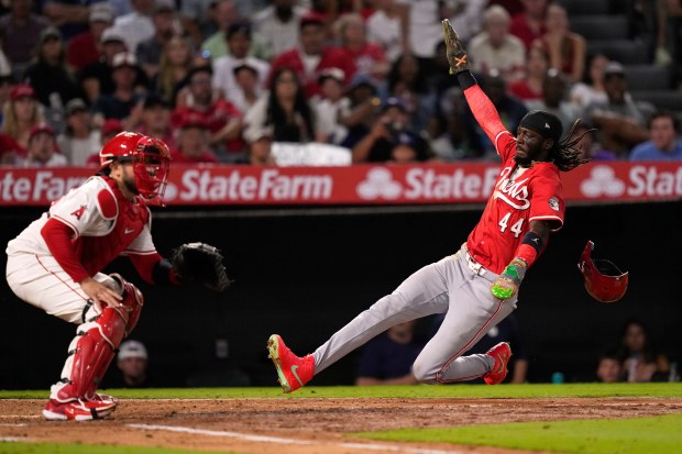 The Cincinnati Reds’ Elly De La Cruz, right, scores on...