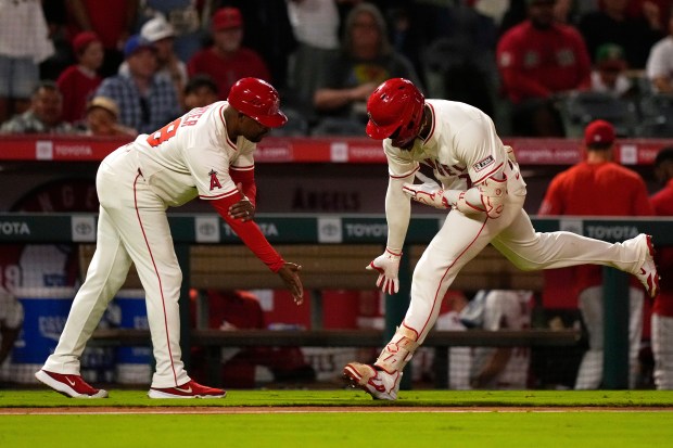 The Angels’ Jo Adell, right, is congratulated by third base...