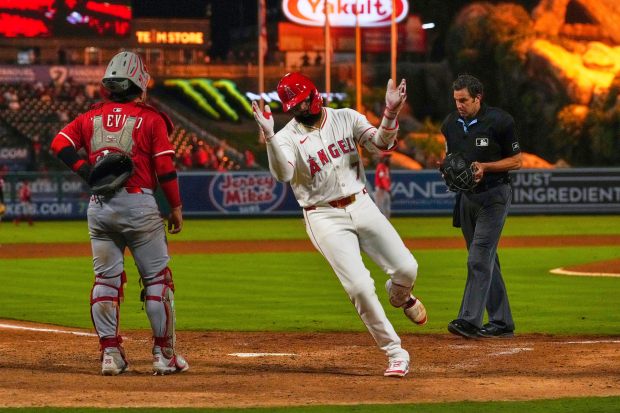 The Angels’ Jo Adell, center, celebrates after hitting a game-tying...
