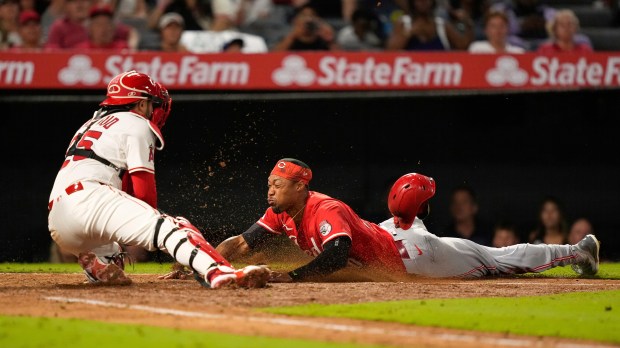 The Cincinnati Reds’ Will Benson, right, is tagged out by...