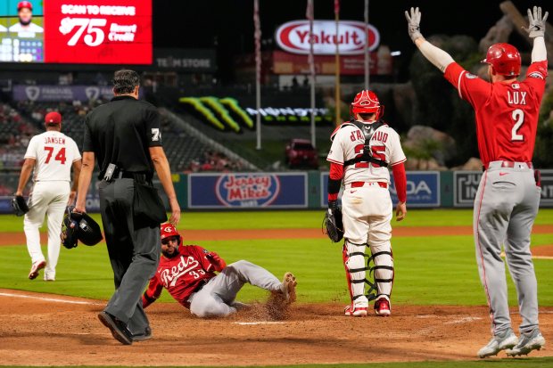 The Cincinnati Reds’ Jose Trevino, second from center, scores on...