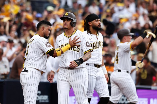 San Diego Padres’ Manny Machado, center, is congratulated by Luis...