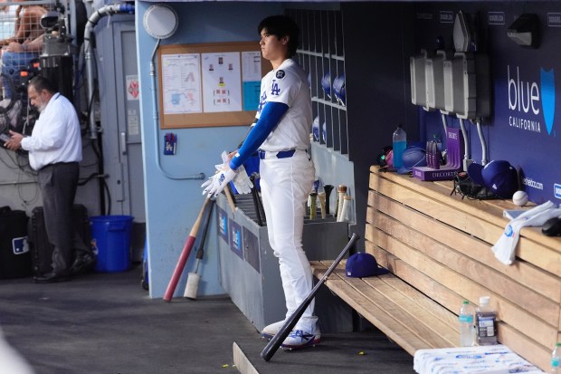 Dodgers star Shohei Ohtani stands in the dugout during the...