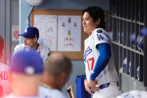 Dodgers star Shohei Ohtani stands in the dugout prior to...