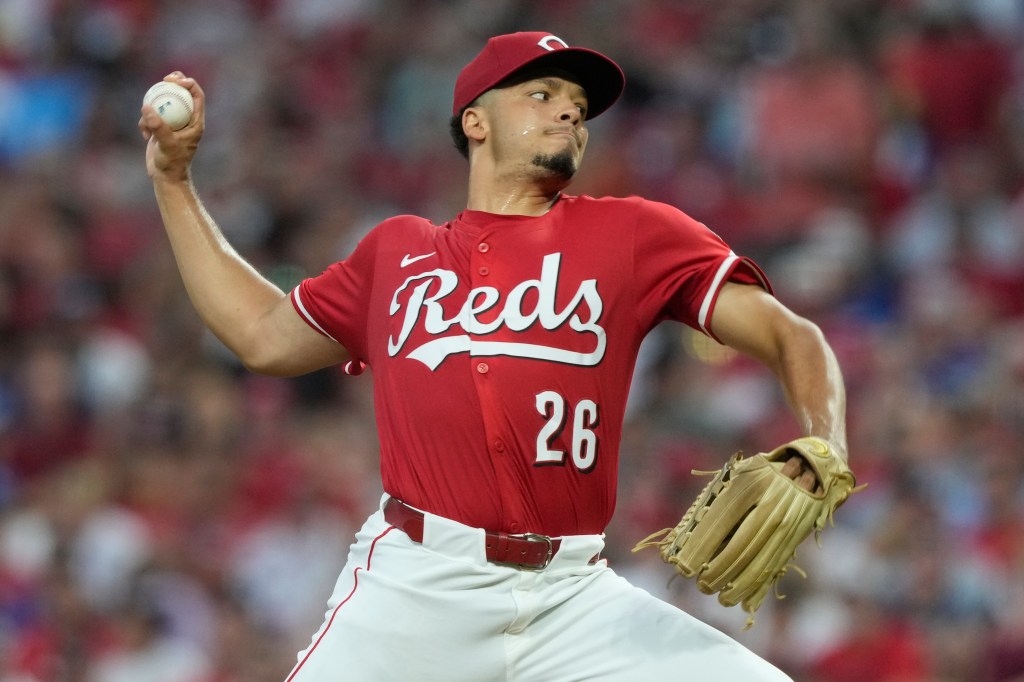 Cincinnati Reds pitcher winds up to throw a baseball.