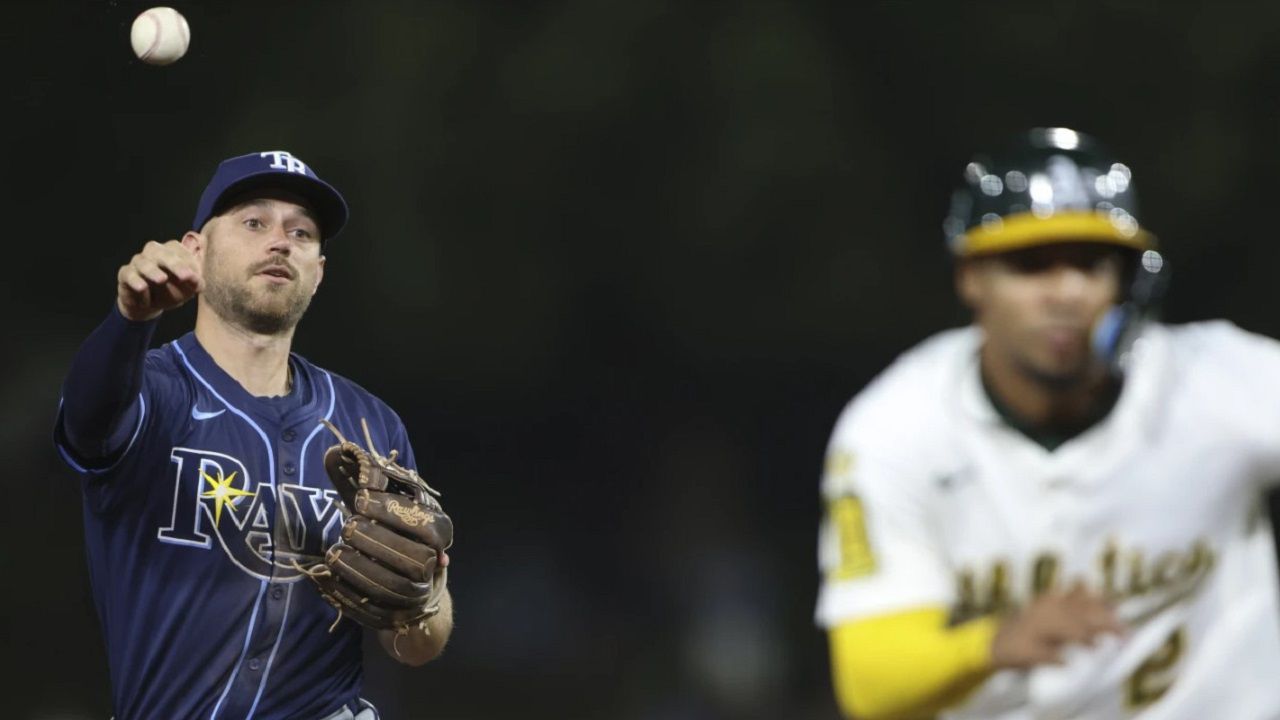Tampa Bay second baseman Brandon Lowe, left, throws to third as Athletics' Darell Hernaiz, right, is called out during a rundown in the eighth inning of the A's 6-0 win Tuesday night in Sacramento, Calif. (AP Photo/Scott Marshall)