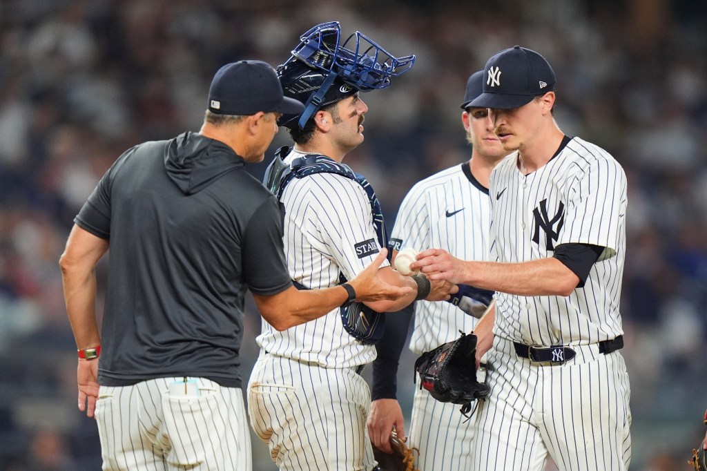 Yankees baseball players and coach conferring.