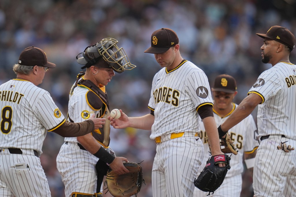 San Diego Padres starting pitcher Michael King, center, hands the ball to manager Mike Shildt (8) as he exits during the third inning of a baseball game against the Boston Red Sox Saturday, Aug. 9, 2025, in San Diego.