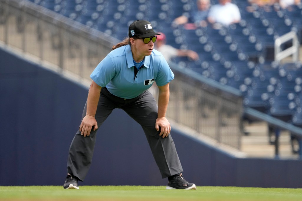 Baseball umpire stretching on the field.