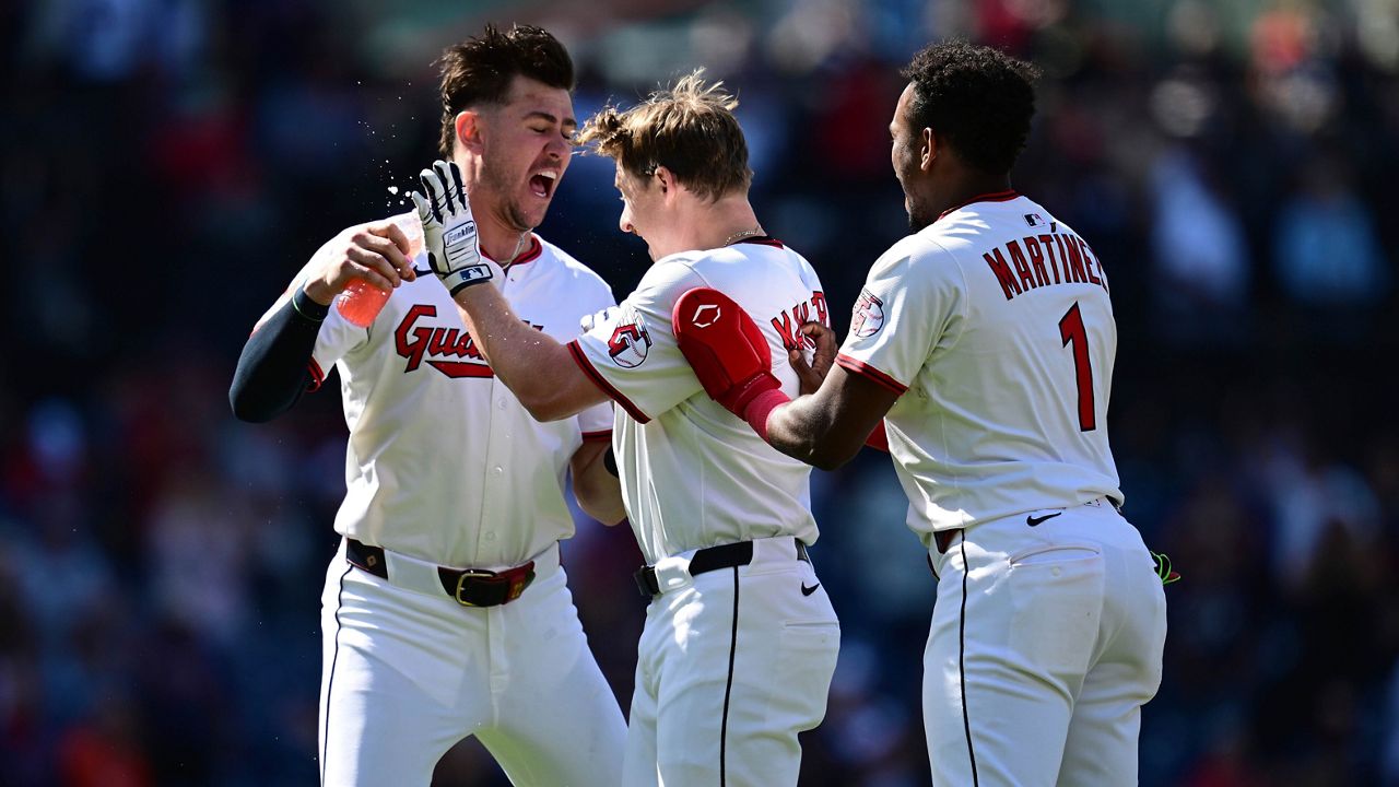Cleveland Guardians second baseman Brayan Rocchio (4) and left fielder Steven Kwan, right, celebrate after the Guardians defeated the Tampa Bay Rays in a baseball game in Cleveland, Tuesday, Aug. 26, 2025. (AP Photo/Sue Ogrocki)