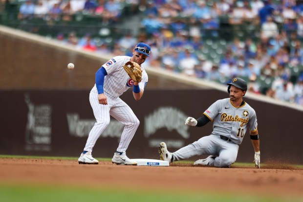 Pittsburgh Pirates outfielder Bryan Reynolds (10) slides safely into second base while Chicago Cubs second base Nico Hoerner (2) keeps him at second base during the first inning against the Pittsburgh Pirates at Wrigley Field on Sunday, Aug. 17, 2025. (Eileen T. Meslar/Chicago Tribune)