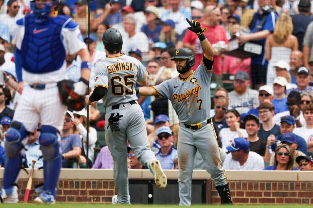 Pittsburgh Pirates shortstop Isiah Kiner-Falefa (7) high-fives outfielder Jack Suwinski (65)after he scored during the sixth inning against the Chicago Cubs at Wrigley Field on Sunday, Aug. 17, 2025. (Eileen T. Meslar/Chicago Tribune)