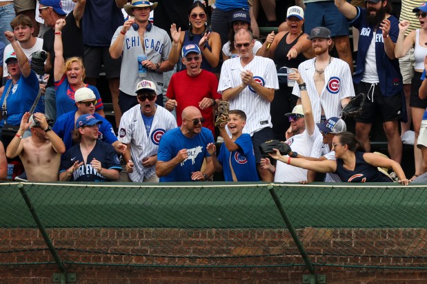 A young Cubs fan catches a ground-rule double from Chicago Cubs outfielder Ian Happ (8) that bounced into the bleachers during the eighth inning against the Pittsburgh Pirates at Wrigley Field on Sunday, Aug. 17, 2025. (Eileen T. Meslar/Chicago Tribune)