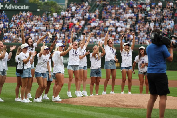 Northwestern University field hockey players cheer after their teammate threw out a ceremonial first pitch before the Chicago Cubs game against the Pittsburgh Pirates at Wrigley Field on Sunday, Aug. 17, 2025. (Eileen T. Meslar/Chicago Tribune)