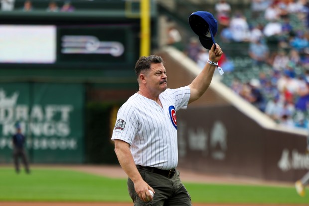 Actor Nick Offerman tips his hat to fans before throwing a ceremonial first pitch before the Chicago Cubs game against the Pittsburgh Pirates at Wrigley Field on Sunday, Aug. 17, 2025. (Eileen T. Meslar/Chicago Tribune)