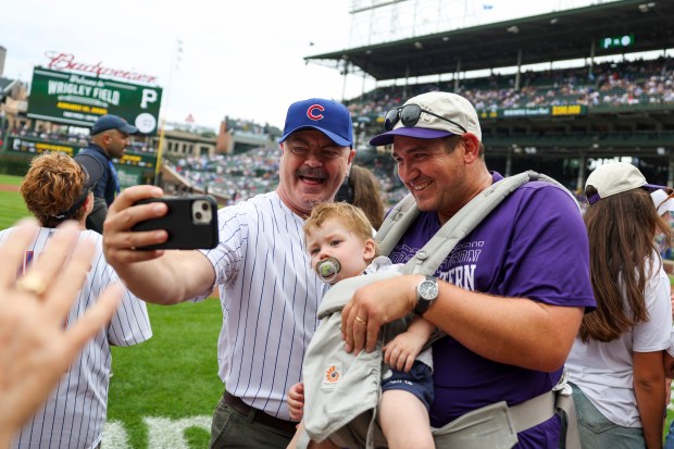 Actor Nick Offerman, left, poses for a selfie with Northwestern field hockey coach Will Byrne and son Simon before Offerman throws out a ceremonial first pitch before the Chicago Cubs game against the Pittsburgh Pirates at Wrigley Field on Sunday, Aug. 17, 2025. (Eileen T. Meslar/Chicago Tribune)