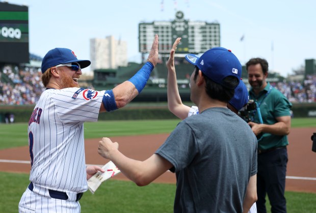 Chicago Cubs first baseman Justin Turner greets fans on the field before facing the Cincinnati Reds on Wednesday, Aug. 6, 2025, at Wrigley Field. (Brian Cassella/Chicago Tribune)