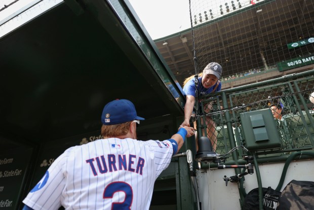 Chicago Cubs first baseman Justin Turner signs an autograph for a fan before facing the Cincinnati Reds on Wednesday, Aug. 6, 2025, at Wrigley Field. (Brian Cassella/Chicago Tribune)