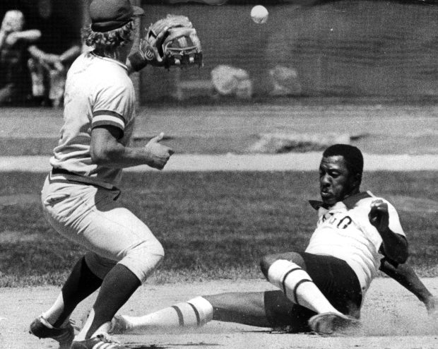 At great risk to his exposed knees, Chicago White Sox outfielder Pat Kelly slides safely into third base on Aug. 8, 1976, after Jim Spencer's fly ball to left field. When throw eluded both Kansas City Royals third baseman George Brett and pitcher Marty Pattin, who was backing up play, Kelly scored first run of White Sox's 5-2 opening-game victory over division-leading Royals. (Edward Wagner Jr./Chicago Tribune)