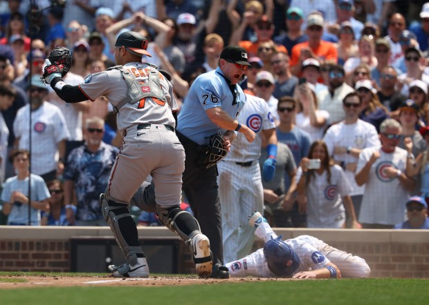 Chicago Cubs catcher Carson Kelly is called out at the plate after a tag by Baltimore Orioles catcher Alex Jackson to end the first inning Sunday, Aug. 3, 2025, at Wrigley Field. (Brian Cassella/Chicago Tribune)