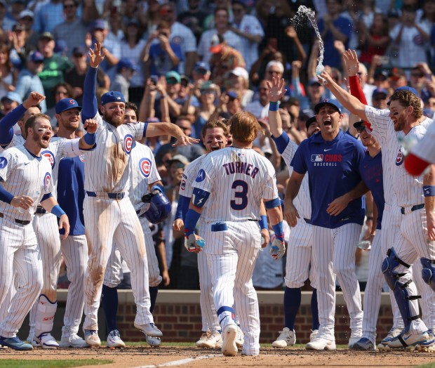 Chicago Cubs teammates wait at home plate for pinch hitter Justin Turner to celebrate his walk-off home run to defeat the Baltimore Orioles, 5-3, on Sunday, Aug. 3, 2025, at Wrigley Field. (Brian Cassella/Chicago Tribune)