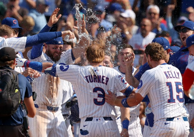 Chicago Cubs teammates wait at home plate for pinch hitter Justin Turner to celebrate his walk-off home run to defeat the Baltimore Orioles, 5-3, on Sunday, Aug. 3, 2025, at Wrigley Field. (Brian Cassella/Chicago Tribune)