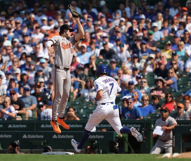 Baltimore Orioles first baseman Coby Mayo leaps to catch an errant throw and Chicago Cubs shortstop Dansby Swanson reaches first base in the ninth inning Sunday, Aug. 3, 2025, at Wrigley Field. (Brian Cassella/Chicago Tribune)