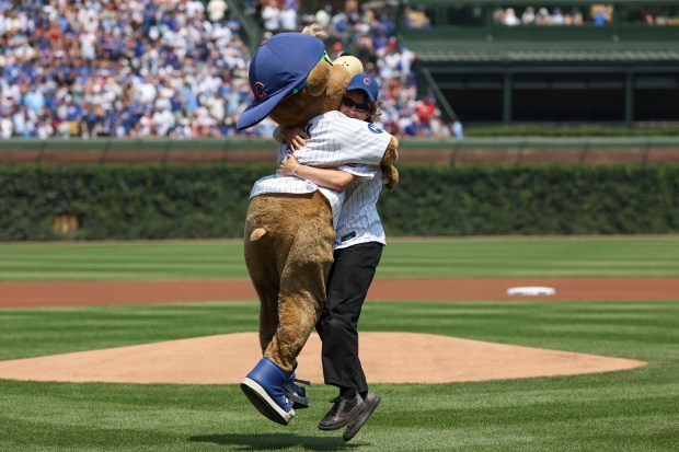 Joe "Djo" Kerry celebrates with Clark the Cub after throwing out a ceremonial first pitch Sunday, Aug. 3, 2025, at Wrigley Field. (Brian Cassella/Chicago Tribune)