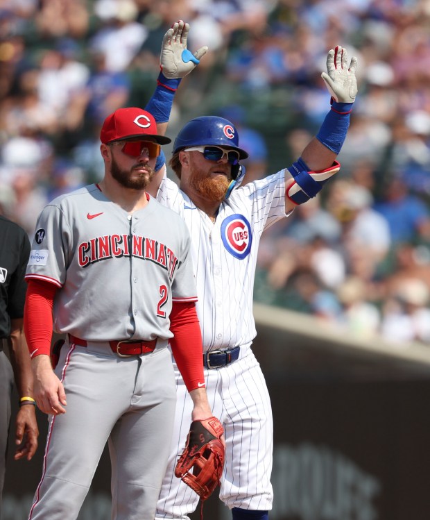 Chicago Cubs first baseman Justin Turner celebrates his double behind Cincinnati Reds second baseman Gavin Lux in the seventh inning Wednesday, Aug. 6, 2025, at Wrigley Field. (Brian Cassella/Chicago Tribune)