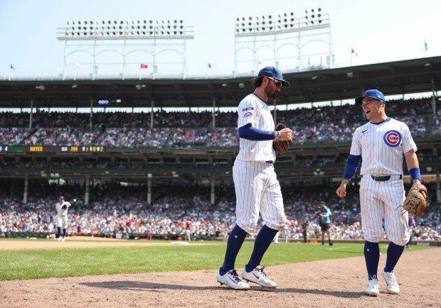 Chicago Cubs shortstop Dansby Swanson, left, and third baseman Matt Shaw celebrate the end of an inning against the Cincinnati Reds on Wednesday, Aug. 6, 2025, at Wrigley Field. (Brian Cassella/Chicago Tribune)