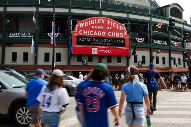 People walk in front of the marquee outside of Wrigley...