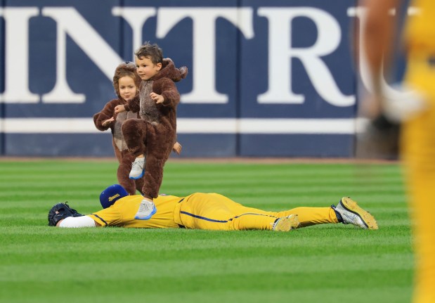 Kids dressed in bear outfits run a race above Savannah Bananas players in the first inning against the Firefighters on Aug. 15, 2025, at Rate Field. (John J. Kim/Chicago Tribune)