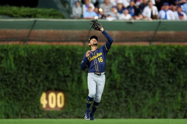 Milwaukee Brewers outfielder Blake Perkins (16) catches a ball from Chicago Cubs first baseman Michael Busch (29) during the first inning at Wrigley Field on Wednesday, Aug. 20, 2025, in Chicago. (Armando L. Sanchez/Chicago Tribune)