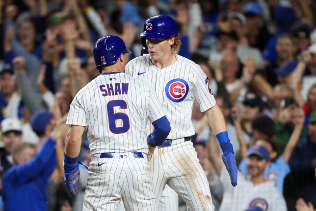 Chicago Cubs outfielder Owen Caissie (19), and third baseman Matt Shaw (6) celebrate after scoring off a three-RBI double from first baseman Michael Busch (29) during the third inning against the Milwaukee Brewers at Wrigley Field on Wednesday, Aug. 20, 2025, in Chicago. (Armando L. Sanchez/Chicago Tribune)